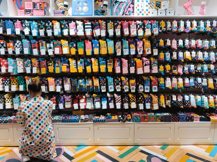 woman crouching in front of display shelf
